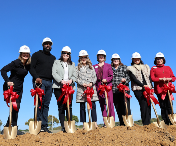  Plano ISD team of 8 with shovels on dirt mound.